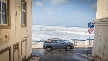 Mini Countryman SE All4 (2024) fotografiert vor dem Atlantik aus einer kleinen Gasse heraus