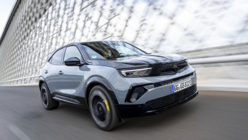 silbergrauer Opel Mokka GSE während der Fahrt über eine Brücke fotografiert