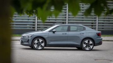 Polestar 2 in grau in der Seitenansicht vor modernem Gebäudeausschnitt