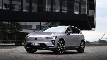 Volvo EX60 in silber stehend vor modernem Gebäude abgelichtet.