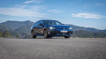 Blauer Passat Variant 2.0 TDI 4Motion schraeg von vorn unten auf Straße fotografiert