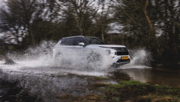 Wasserdurchfahrt mit spritzendem Wasser im Outlander von Mitsubishi