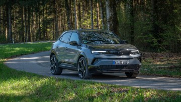 Opel Mokka GSE auf einer kurvenreichen Landstraße in Halbschatten aufgenommen.