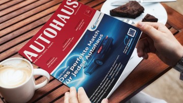 AUTOHAUS 11/2026 liegt auf einem Tisch mit Kaffee und Kuchen