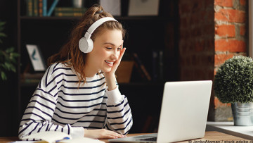 Eine Frau die im Homeoffice an einem Laptop arbeitet.