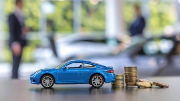 Ein Spielzeugauto und Geld und in einem Showroom