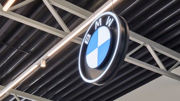 Ein BMW-Logo hängt in einem Autohaus-Showroom