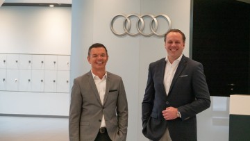 Stefan Quary und Carsten Kortüm in der Audi Zentrale in Ingolstadt fotografiert vor Audi-Logo