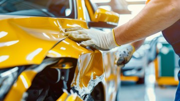 Ein Mechaniker prüft einen Fahrzeugschaden