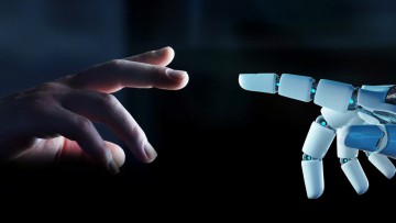 Einen Menschenhand streckt sich nach einer Roboterhand