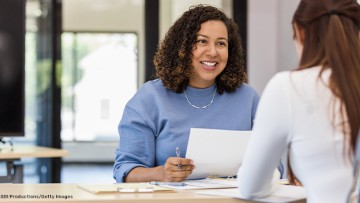 Zwei Frauen sitzen an einem Tisch und führen ein Bewerbungsgespräch