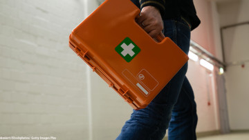 Mann mit Erste-Hilfe-Koffer in der Hand