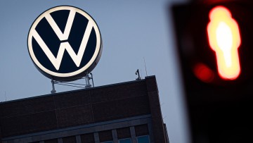 Ein VW-Logo vor einer roten Ampel