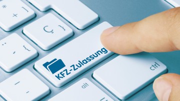 Finger drückt auf einer PC-Tastatur auf die Taste "Kfz-Zulassung"