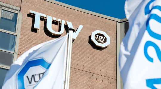 Unternehmensgebäude von TÜV SÜD mit Logo und Fahnen