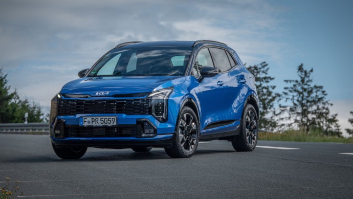 Kia Sportage in Blue Flame Metallic schräg von vorn gegen den Himmel fotografiert