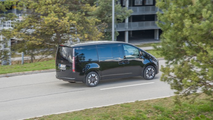 Hyundai Staria in schwarz fahrend von der Seite vor Allianz-Arena