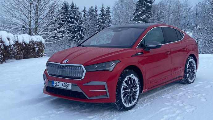 Skoda Enyaq in rot im Schnee von vorn fotografiert