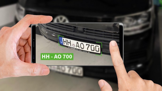 Händler führt mit dem Smartphone und AlphaController einen Kennzeichen-Scan durch