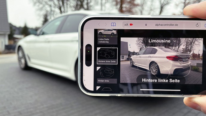 Händler führt mit dem Smartphone und AlphaController eine Remote-Fahrzeugbewertung aus