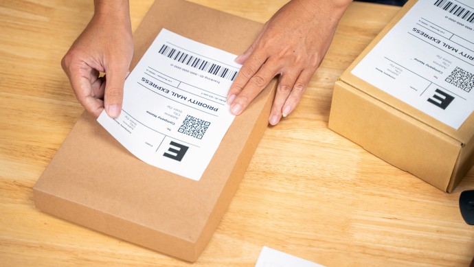 Paketscheine werden auf Pakete geklebt