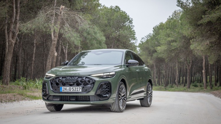 Audi Q5 Sportback des Jahres 2025 in Distriktgrün Metallic auf Schotterweg von schräg vorn fotografiert