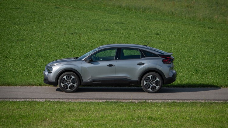 Citroen C4 You (2024) in der Seitenansicht auf Asphalt vor grüner Wiese im Sommer aufgenommen