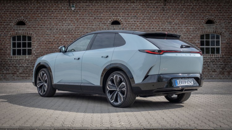 Mazda CX-6e von hinten vor Ziegelwand fotografiert