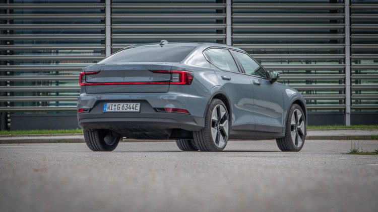 Polestar 2 schraeg von hinten vor einer Glas-Alu-Hauswand fotografiert