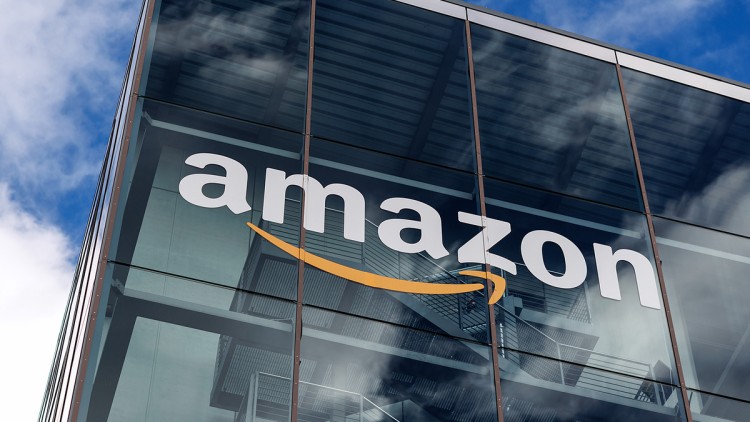 Das Logo und der Schriftzug vom global agierenden Onlineversandhändler Amazon ist am 27.01.2025 an der Fassade der Zentrale von Amazon Deutschland in der Parkstadt Schwabing in München (Bayern) unter dem blauen Himmel zu sehen.