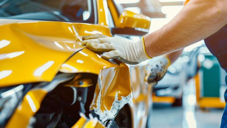 Ein Mechaniker prüft einen Fahrzeugschaden