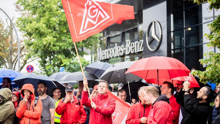 Teilnehmer einer Kundgebung im Rahmen eines bundesweiten Aktionstages für die Zukunft der Beschäftigten der Mercedes-Benz Niederlassungen haben sich vor dem dem Berliner Mercedes-Benz-Niederlassungscenter versammelt
