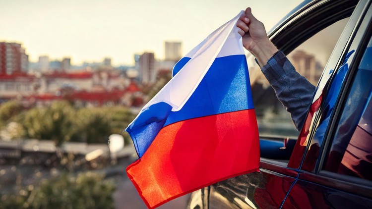 Eine russische Fahne weht aus einem Autofenster