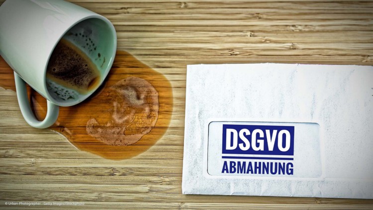 DSGVO-Abmahnung auf einem Tisch mit einer umgekippten Kaffeetasse