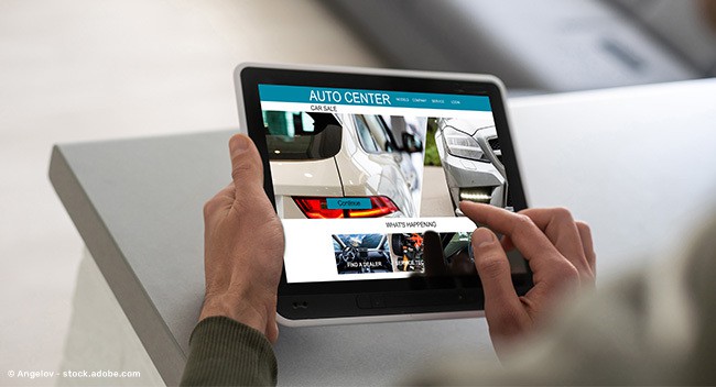 Mann schaut sich die Website eines Autohauses auf seinem Tablet an.