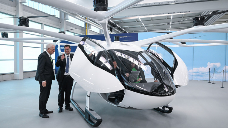 Winfried Kretschmann (Bündnis 90/Die Grünen, l), Ministerpräsident von Baden-Württemberg, und Stefan Klocke, Vorsitzender des Beirats von Volocopter, schauen sich einen Volocopter an. 