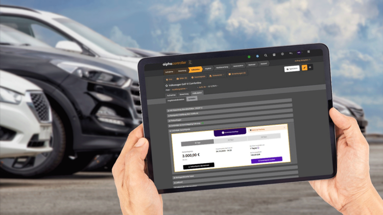 Händler hält ein Tablet mit Alpha Online Software vor seine Gebrauchtwagen