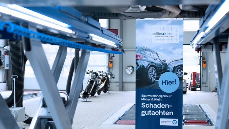 Hebebühne mit Werbeschild TÜV SÜD Schadengutachten