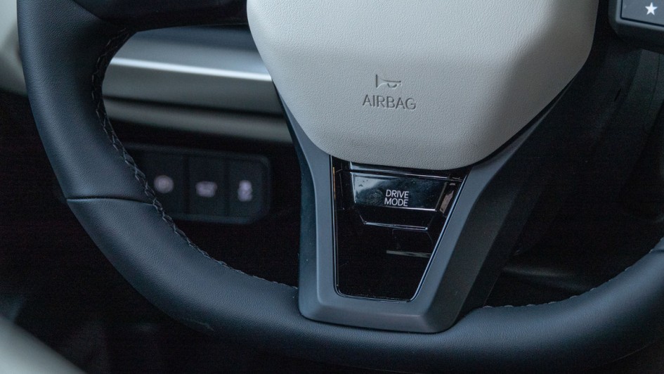 Taste für den Fahrmodus in der Lenkradspange unten im Kia EV4 Fastback