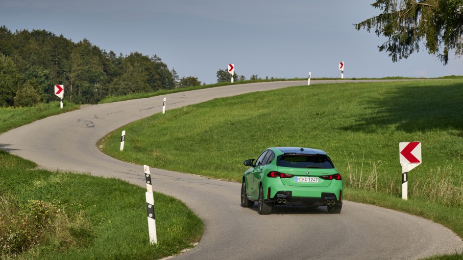 Foto von Kurvenstraße mit dem grünen BMW M135 xDrive als Hauptmotiv