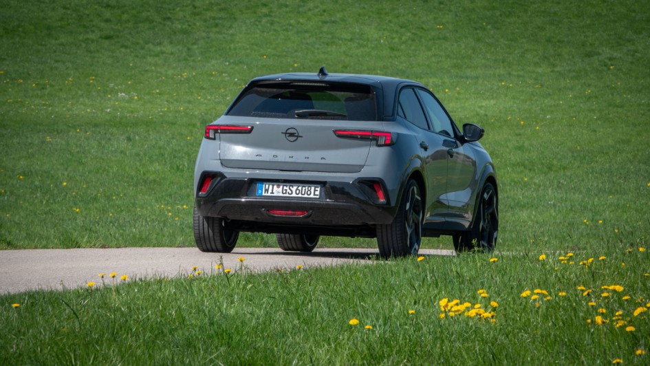 Opel Mokka GSE von hinten aufgenommen bei Sonne vor grüner Wiese