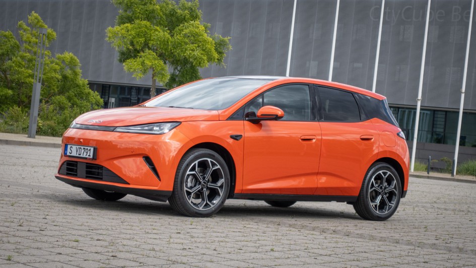 Schräg von vorn auf Parkplatz fotografierter BYD Dolphin G in orange