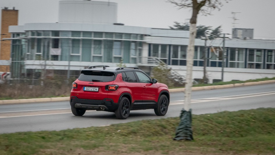 Mitzieher vom fahrenden Jeep Avenger, rot lackiert bei wolkigem Wetter