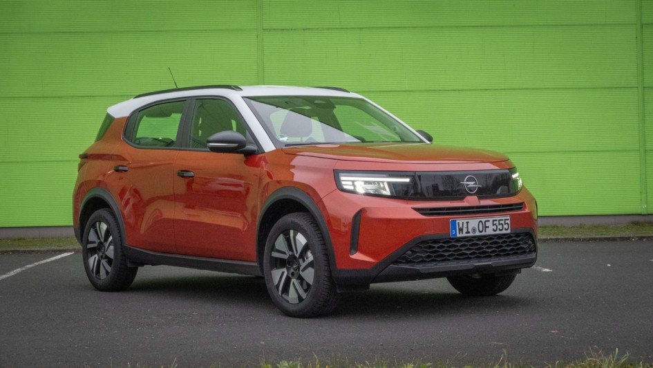 Orangefarbener Opel Frontera vor grüner Wand fotografiert