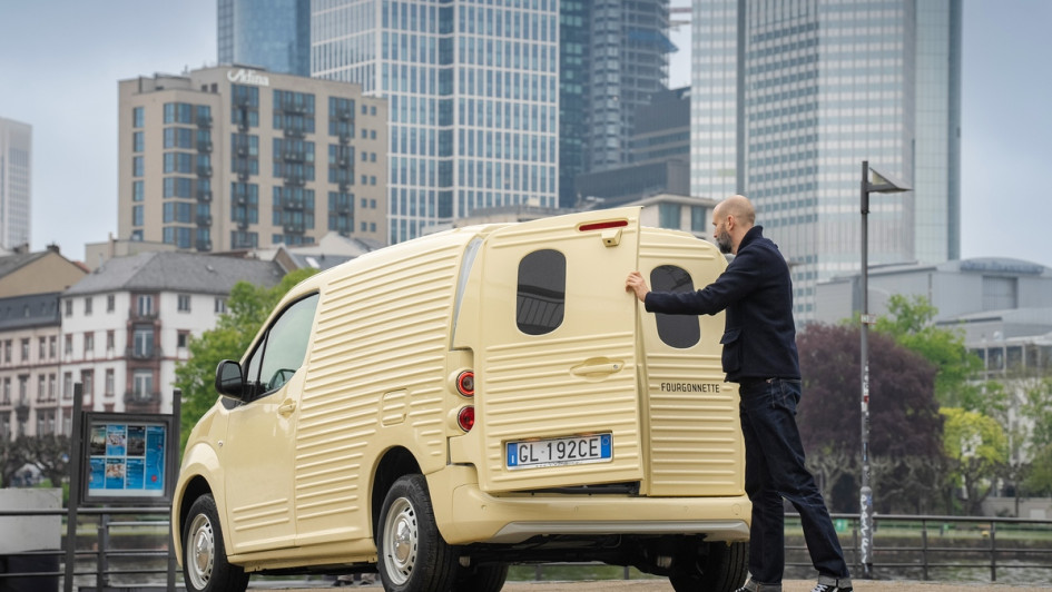 Citroen Berlingo 2CV Fourgonnette Heckansicht mit Person, die Gepäck in den Transporter einlädt. Situation entstand vor Frankfurter Skyline