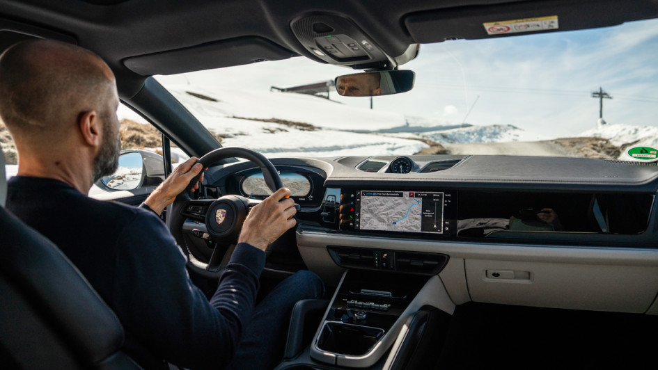 Porsche Cayenne S Coupé Innenaufname während der Fahrt mit Fahrer von schraeg hinten aufs Armaturenbrett