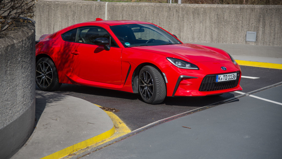 Toyota GR86 in rot schraeg von vorn auf Garagenauffahrt