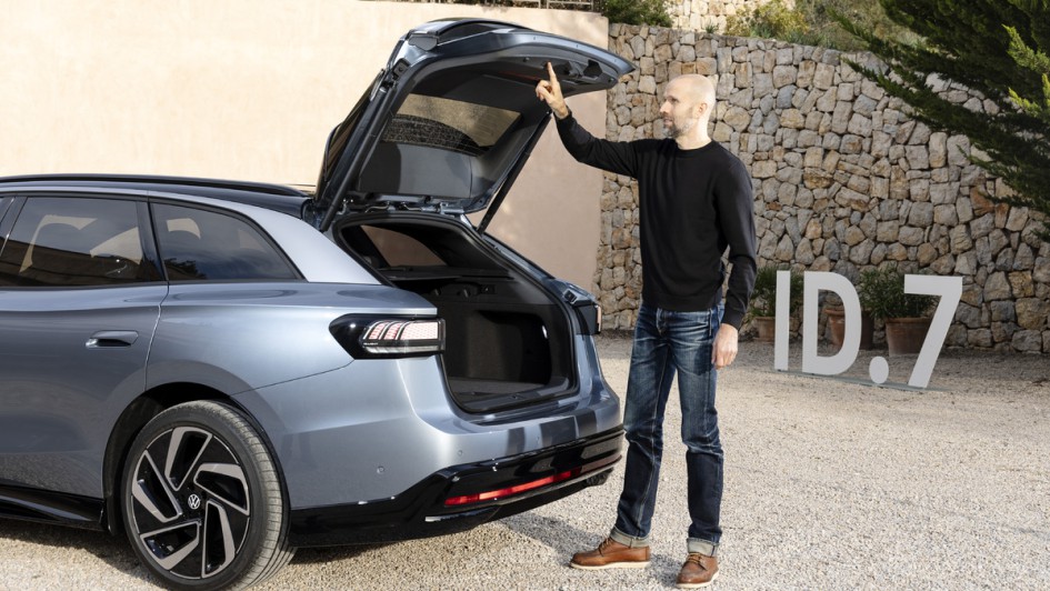 Mensch stehend beim Schließen per Knopfdruck der Heckklappe des VW ID.7 Kombi