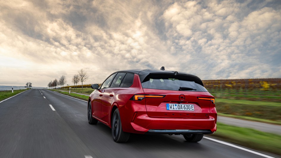 Opel Astra Sports Tourer Electric fahrend auf Straße von hinten fotografiert
