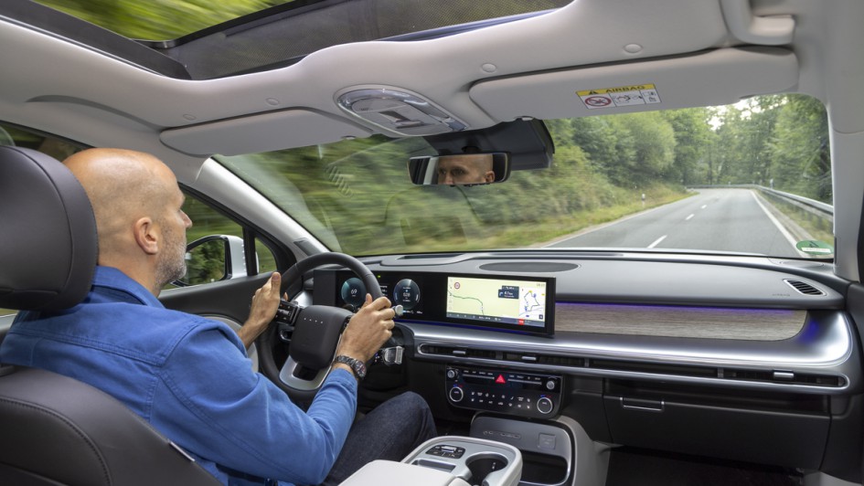 Fahrer im Hyundai Ioniq 9 von hinten über die Schulter des Fahrers nach von fotografiert